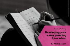 Black and white image of a hand writing in a book